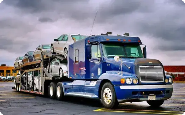 a blue nose open truck loaded with cars